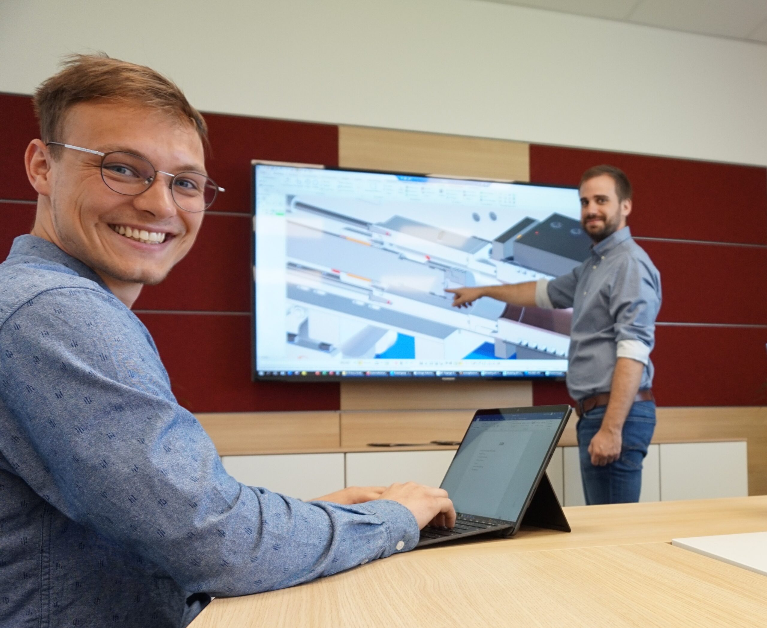 Zwei Mitarbeiter von Haginger im Vertriebsinnendienst präsentieren eine 3D-Konstruktion einer Sondermaschine auf dem Bildschirm